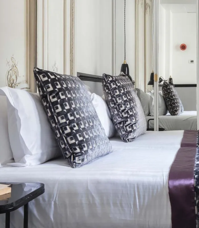 Lit d’une chambre Twin avec des draps blancs et des oreillers noirs et blancs à l’Hôtel Malte