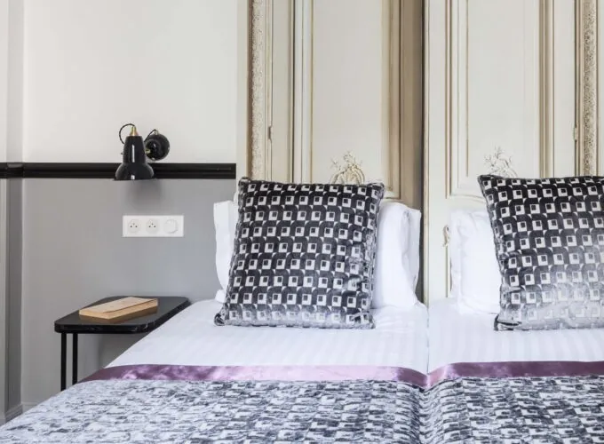Lit d’une chambre Twin avec un oreiller à motifs noir et blanc à l’Hôtel Malte