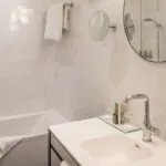 Salle de bain d’une chambre Twin avec un lavabo, un miroir et une baignoire à l’Hôtel Malte