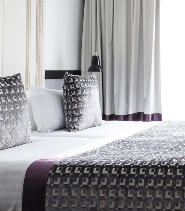 Lit de la chambre Twin Supérieure avec une couverture à motifs et des oreillers à l’Hôtel Malte