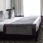 Chambre de la chambre Twin Supérieure avec un lit et des rideaux violets à l’Hôtel Malte