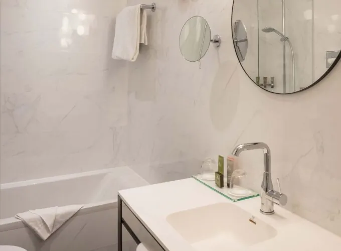 Salle de bain d’une chambre Twin Supérieure avec un lavabo, un miroir et une baignoire à l’Hôtel Malte