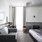 Chambre Privilège avec un canapé et une télévision à écran plat à l’Hôtel Malte