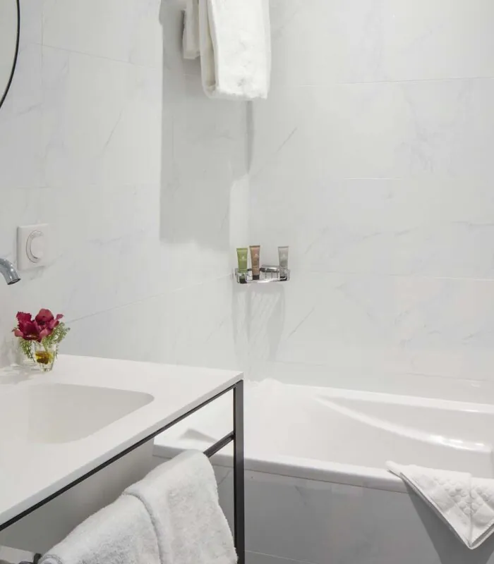 Salle de bain d’une chambre Privilège avec un lavabo, une baignoire et un miroir à l’Hôtel Malte