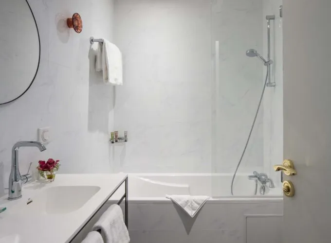 Salle de bain d’une chambre Privilège avec une baignoire et un lavabo à l’Hôtel Malte