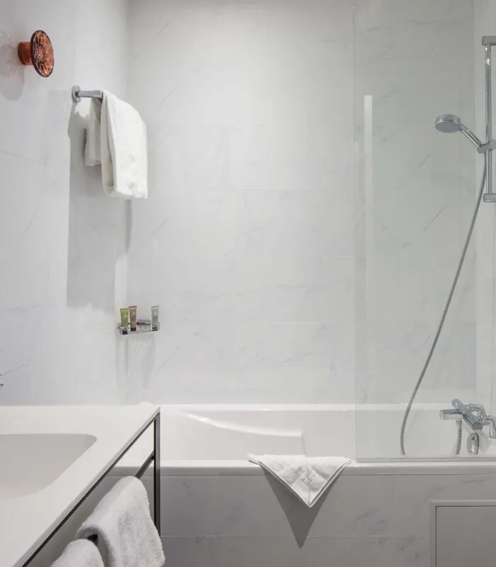 Salle de bain d’une chambre Privilège avec une baignoire et un lavabo à l’Hôtel Malte