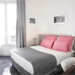 Chambre Double avec une couverture à rayures et des oreillers roses à l’Hôtel Monterosa