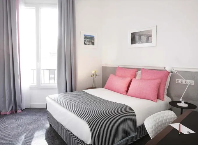 Chambre Double avec une couverture à rayures et des oreillers roses à l’Hôtel Monterosa