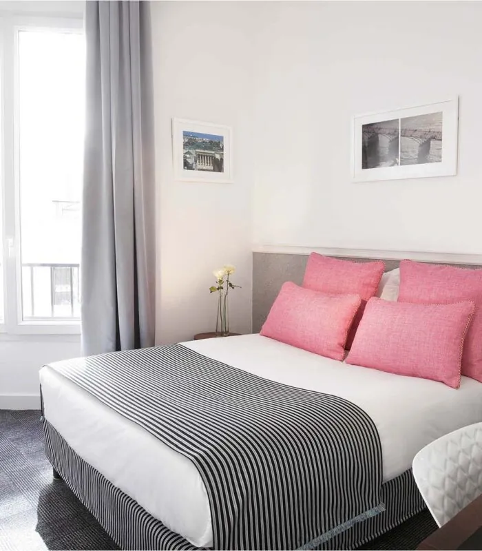 Chambre Double avec une couverture à rayures et des oreillers roses à l’Hôtel Monterosa