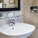 Lavabo de la salle de bain d’une chambre Single avec un panneau à l’Hôtel Monterosa