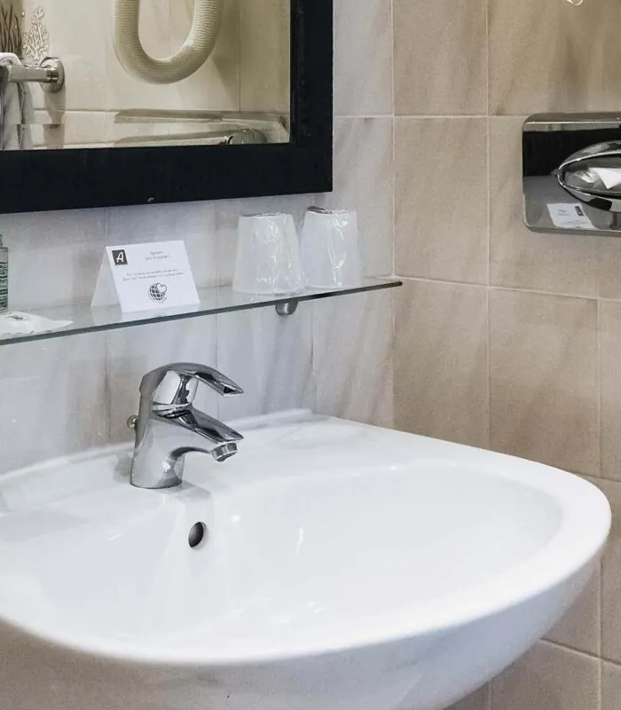 Lavabo de la salle de bain d’une chambre Single avec un panneau à l’Hôtel Monterosa