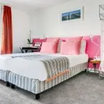 Chambre Twin avec deux lits et un mur rose à l’Hôtel Monterosa
