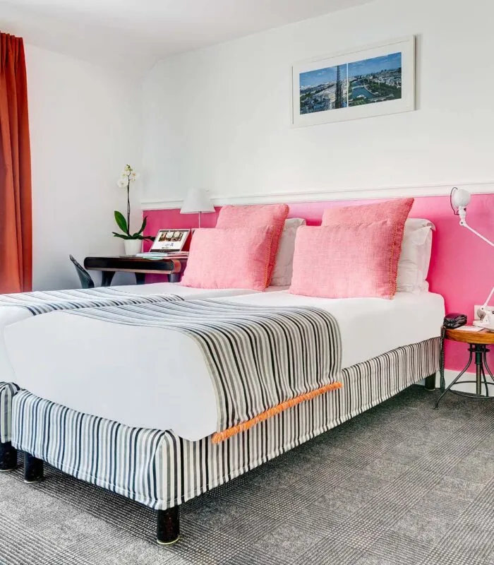 Chambre Twin avec deux lits et un mur rose à l’Hôtel Monterosa