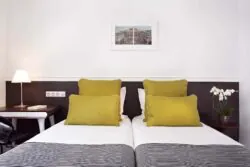 Chambre Twin à l’Hôtel Monterosa à Paris avec deux lits, offrant un cadre confortable et tranquille pour les voyageurs seuls, amis ou collègues