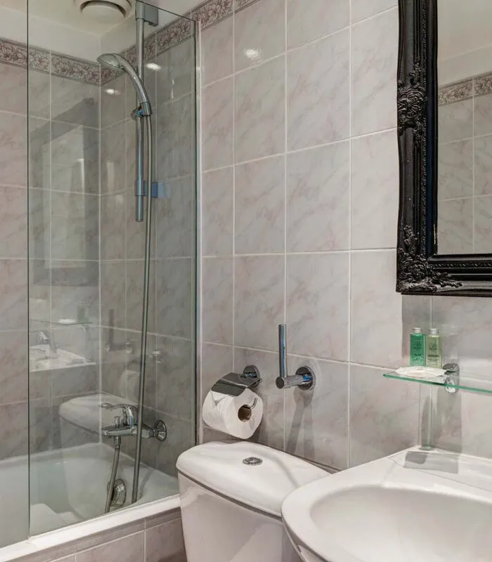 Salle de bain d’une chambre Twin avec du carrelage blanc et un miroir noir à l’Hôtel Monterosa