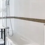 Salle de bain d’une chambre Twin avec une baignoire, un lavabo et un miroir à l’Hôtel Monterosa
