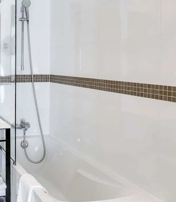 Salle de bain d’une chambre Twin avec une baignoire, un lavabo et un miroir à l’Hôtel Monterosa