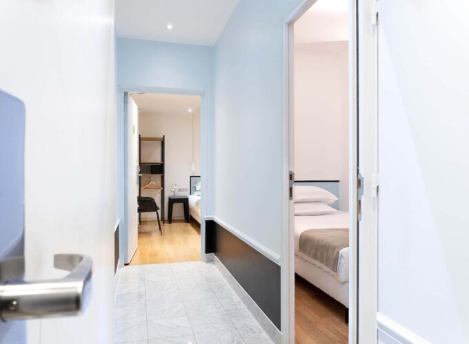 Couloir privatisé menant aux chambres de la chambre communicante avec vue sur un lit simple à l’Hôtel Palm