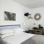 Chambre d’une chambre Double avec un miroir rond accroché au mur au-dessus d’un bureau à l’Hôtel Palm