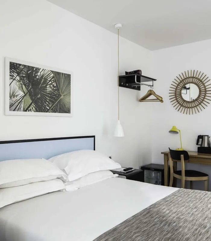 Chambre d’une chambre Double avec un miroir rond accroché au mur au-dessus d’un bureau à l’Hôtel Palm