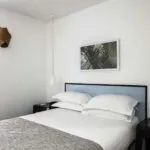 Chambre d’une chambre double avec un lit, une table de chevet et un tableau au mur à l’Hôtel Palm