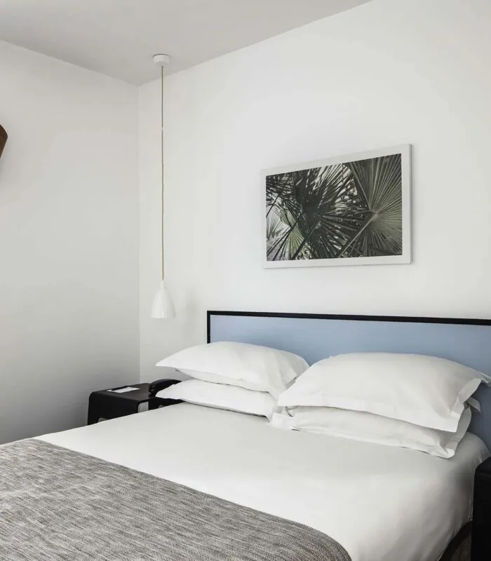 Chambre d’une chambre double avec un lit, une table de chevet et un tableau au mur à l’Hôtel Palm