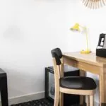 Bureau d’une chambre double avec une lampe jaune et une télécommande posée dessus à l’Hôtel Palm