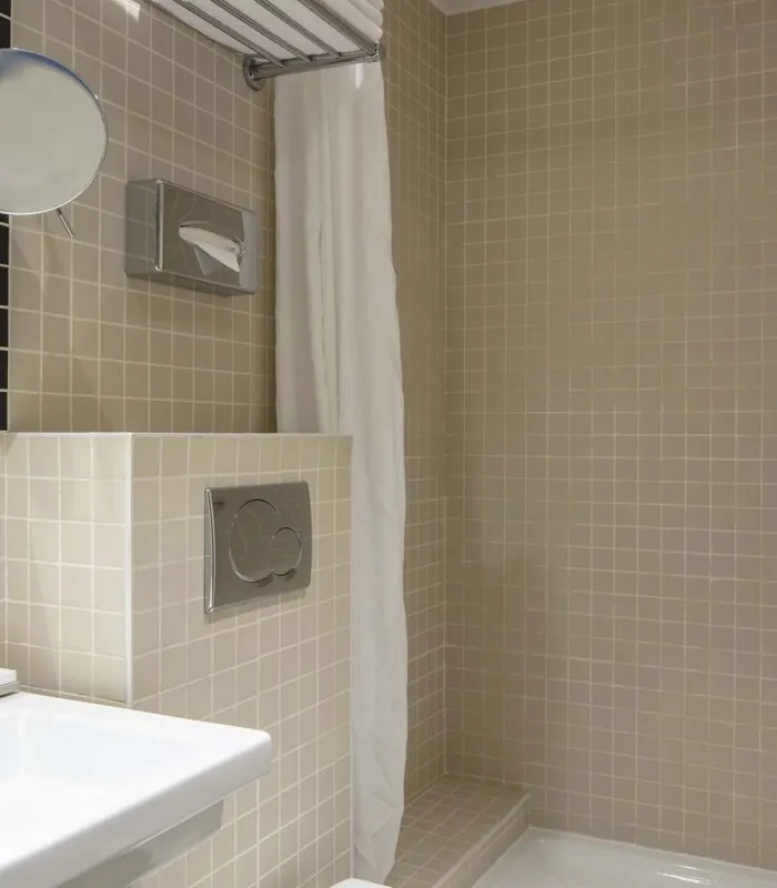 Salle de bain d’une chambre double avec un lavabo, un miroir et une douche à l’Hôtel Palm