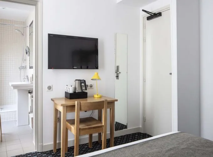 Une des 2 chambres d’une chambre familiale avec une télévision à écran plat fixée au mur à l’Hôtel Palm