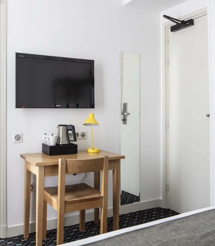 Une des 2 chambres d’une chambre familiale avec une télévision à écran plat fixée au mur à l’Hôtel Palm