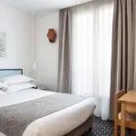 Une chambre d’une chambre familiale avec un lit et un bureau à l’Hôtel Palm