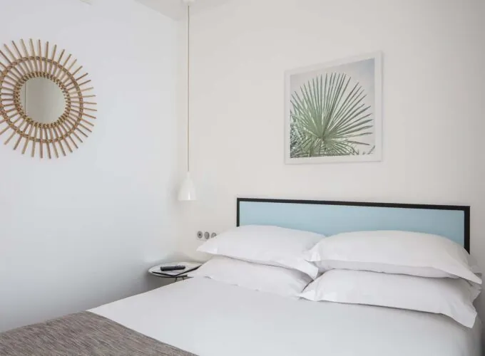 Une chambre d’une chambre familiale avec un lit et un tableau accroché au mur au-dessus à l’Hôtel Palm