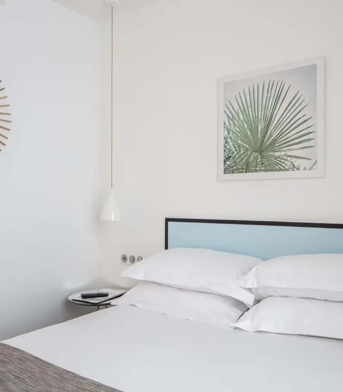 Une chambre d’une chambre familiale avec un lit et un tableau accroché au mur au-dessus à l’Hôtel Palm