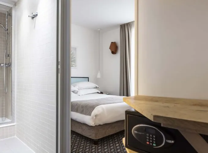 Une chambre d’une chambre familiale avec un coffre-fort et un lit à l’Hôtel Palm