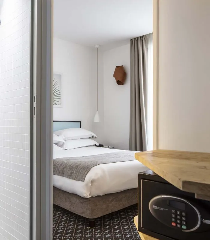 Une chambre d’une chambre familiale avec un coffre-fort et un lit à l’Hôtel Palm