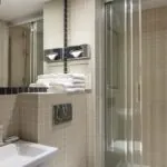 Salle de bain d’une des 2 chambres d’une chambre familiale avec un lavabo et une cabine de douche à l’Hôtel Palm