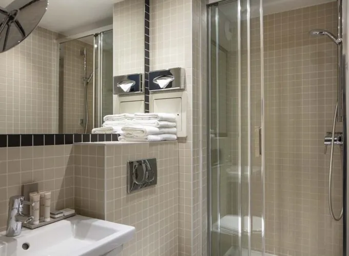 Salle de bain d’une des 2 chambres d’une chambre familiale avec un lavabo et une cabine de douche à l’Hôtel Palm