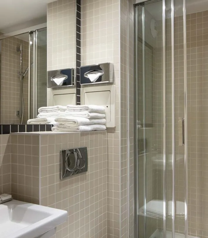 Salle de bain d’une des 2 chambres d’une chambre familiale avec un lavabo et une cabine de douche à l’Hôtel Palm