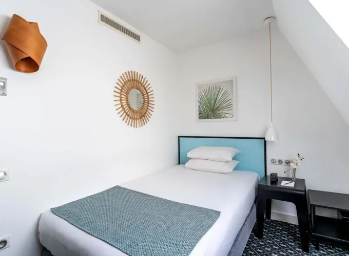 Chambre d’une chambre Single avec un lit simple et un tableau au mur à l’Hôtel Palm