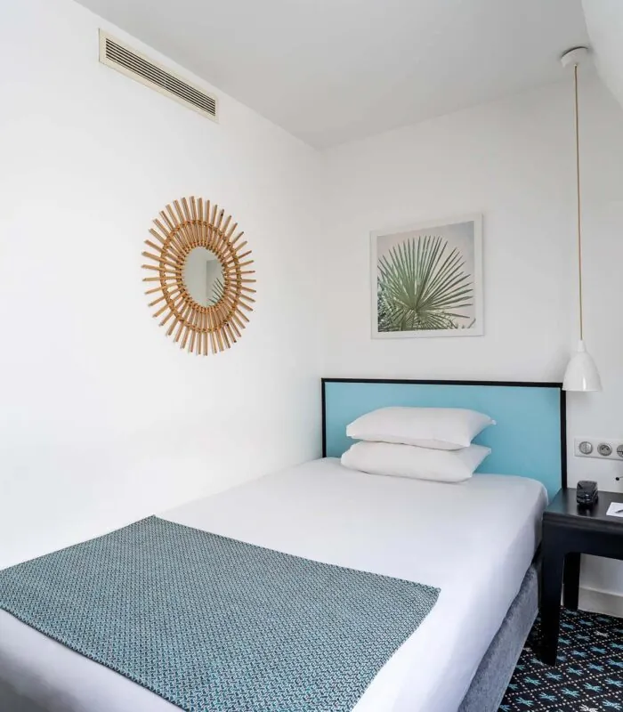 Chambre d’une chambre Single avec un lit simple et un tableau au mur à l’Hôtel Palm