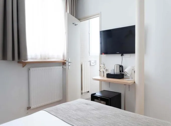 Chambre de la chambre Single Cocoon avec une télévision à écran plat fixée au mur à l’Hôtel Palm