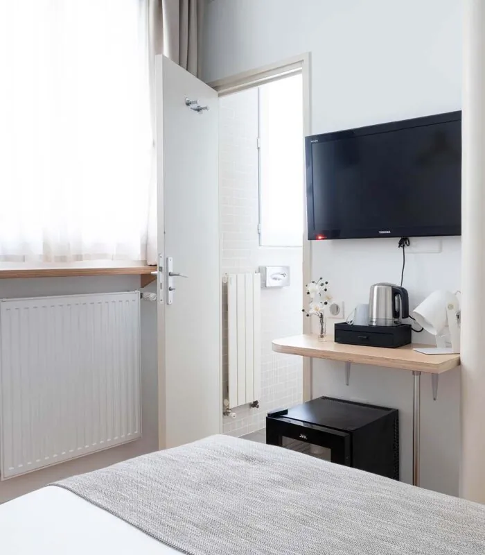 Chambre de la chambre Single Cocoon avec une télévision à écran plat fixée au mur à l’Hôtel Palm