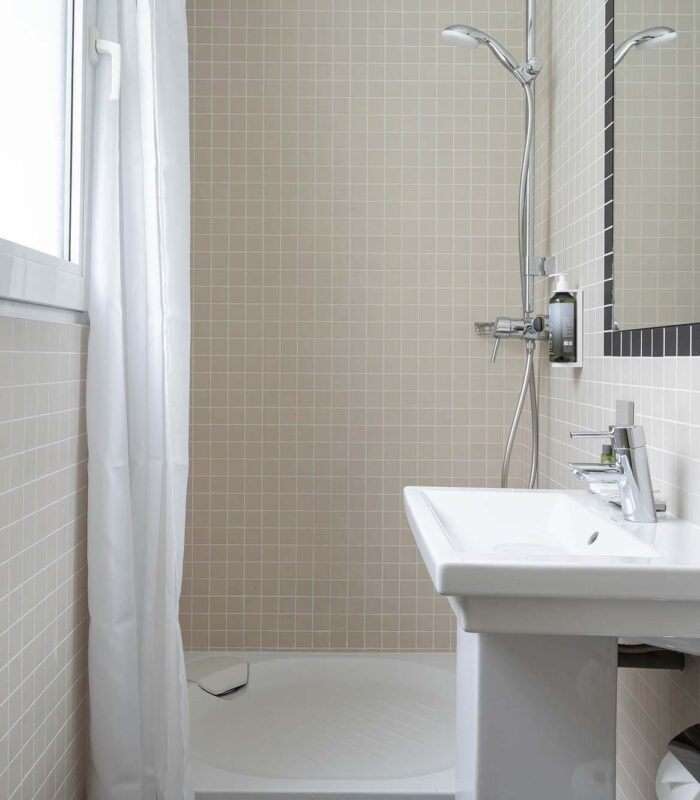 Salle de bain de la chambre Single Cocoon avec un lavabo, un miroir et une douche à l’Hôtel Palm
