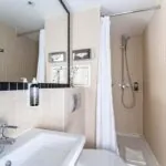 Salle de bain d’une chambre Single avec des toilettes, un lavabo et un rideau de douche à l’Hôtel Palm