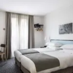 Chambre Twin avec deux lits et un bureau à l’Hôtel Palm