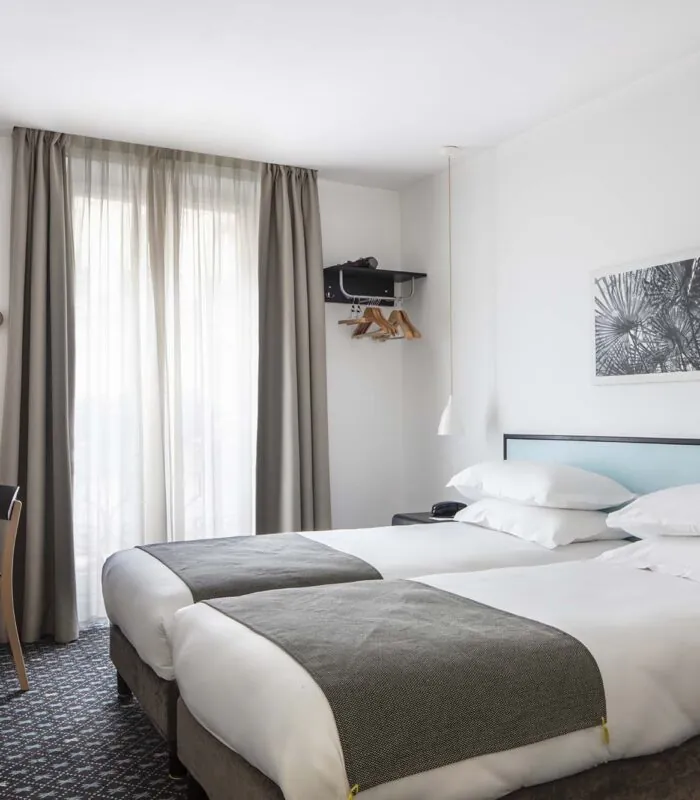 Chambre Twin avec deux lits et un bureau à l’Hôtel Palm