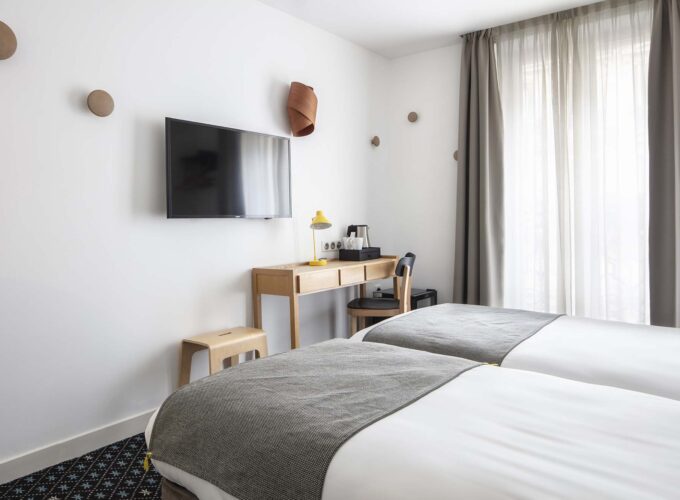 Chambre Twin avec deux lits, un bureau et une télévision à écran plat à l’Hôtel Palm