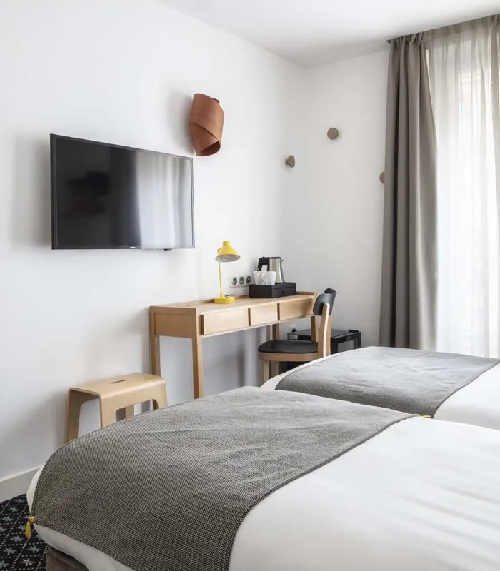 Chambre Twin avec deux lits, un bureau et une télévision à écran plat à l’Hôtel Palm
