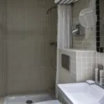 Salle de bain de la chambre Twin avec une douche et un lavabo à l’Hôtel Palm