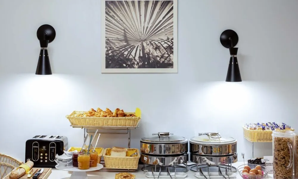 Petit-déjeuner buffet de l’Hôtel Palm à Paris avec viennoiseries, pains frais, fromages, charcuterie, yaourts, fruits frais et secs, et céréales